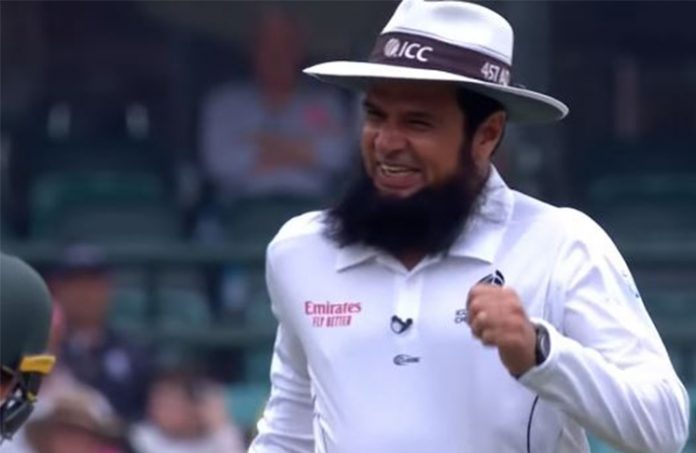 Cricket umpire with a beard, wearing an ICC hat, smiling and celebrating during a match. The image captures his joyful reaction after making a significant decision, highlighting his role in setting cricket umpire records.
