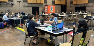 2024 North American Scrabble Championship: Final | USA’s Joshua Winner; Pak’s Waseem Runner-up Players at the 2024 North American Scrabble Championship in a large hall, seated around tables with Scrabble boards and laptops